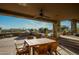 Covered patio with ceiling fan, stone columns, outdoor grill, seating, and beautiful desert views at 41688 N 111Th Pl, Scottsdale, AZ 85262