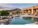 A luxurious backyard pool and patio with lounge areas, desert landscaping, and a mountain view at 41688 N 111Th Pl, Scottsdale, AZ 85262