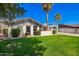 Charming single-story home featuring desert landscaping, a covered carport, and mature palm trees at 4630 W El Caminito Dr, Glendale, AZ 85302