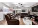 Open-concept living room with a stone accent wall, leather couches, and seamless flow to the dining area at 4630 W El Caminito Dr, Glendale, AZ 85302