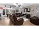 Open-concept living room with a stone accent wall, leather couches, and seamless flow to the dining area at 4630 W El Caminito Dr, Glendale, AZ 85302