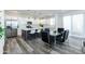 Modern kitchen with stainless steel appliances, white cabinets, a gray island with seating, and a dining area with a glass table at 470 S Soho Ln # 1, Chandler, AZ 85225