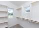 Walk-in closet features built in shelving, wood rods for hanging clothes, and window to let in natural light at 470 S Soho Ln # 1, Chandler, AZ 85225