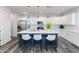 White kitchen with a gray center island featuring barstool seating, pendant lighting, and stainless steel appliances at 482 S Soho Ln # 3, Chandler, AZ 85225