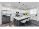 Spacious white kitchen featuring an island with seating, stainless steel appliances, and herringbone backsplash at 482 S Soho Ln # 3, Chandler, AZ 85225