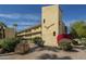 Multi-story building featuring desert landscaping, stucco walls, and a roadrunner painted on the side at 4950 N Miller Rd # 243, Scottsdale, AZ 85251