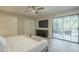 Bright main bedroom featuring a sliding glass door to a balcony, neutral walls, and wood floors at 4950 N Miller Rd # 243, Scottsdale, AZ 85251