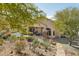 Expansive backyard with a covered patio, pergola, lush desert landscaping, and stone accents at 5310 W Melinda Ln, Glendale, AZ 85308