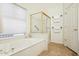 Bright bathroom with a soaking tub and a glass-enclosed shower stall at 5310 W Melinda Ln, Glendale, AZ 85308