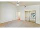 Bedroom with neutral carpet, white walls, a ceiling fan, and mirrored closet doors at 5310 W Melinda Ln, Glendale, AZ 85308