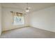 Neutral bedroom with a window, curtains, ceiling fan and carpet flooring at 5310 W Melinda Ln, Glendale, AZ 85308