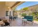 Inviting covered patio with comfortable seating, views of desert landscaping, and a tranquil water feature at 5310 W Melinda Ln, Glendale, AZ 85308