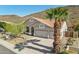 Well-kept home featuring a tile roof, three-car garage, and mature palm trees in a scenic setting at 5310 W Melinda Ln, Glendale, AZ 85308