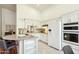 Bright, white kitchen with granite countertops, stainless steel appliances and a breakfast bar at 5310 W Melinda Ln, Glendale, AZ 85308