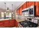 Well-lit kitchen featuring stainless steel appliances, granite countertops, and mosaic tile backsplash at 6129 S White Pl, Chandler, AZ 85249