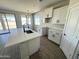 Bright kitchen featuring white cabinets, stainless steel appliances, an island, and wood flooring at 6250 S Dean Rd, Buckeye, AZ 85326