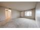 Open living room area with neutral paint, carpeted floors, and access to other rooms at 6331 W Eva St, Glendale, AZ 85302