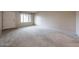 Bright living room featuring neutral paint, carpeted flooring, and a window for natural light at 6331 W Eva St, Glendale, AZ 85302