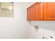 A well-lit laundry room features storage cabinets and window at 6838 W Lynne Ln, Laveen, AZ 85339