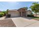 Inviting single-story home featuring a spacious driveway, a two-car garage, and desert landscaping at 6993 S Ruby Dr, Chandler, AZ 85249