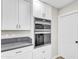 Kitchen showcasing stainless steel double ovens and ample white cabinet storage at 7745 N 33Rd Ave, Phoenix, AZ 85051