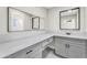 Modern vanity with grey cabinets, white countertop, and dual mirrors at 7745 N 33Rd Ave, Phoenix, AZ 85051