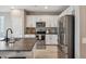 Contemporary kitchen featuring white cabinetry, stainless steel appliances, and a dark countertop with barstool seating at 7949 E Boise St, Mesa, AZ 85207