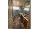Bathroom featuring wood-look floor, double sink vanity, two windows providing natural light, and a large mirror at 8863 W Greer Ave, Peoria, AZ 85345