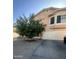 Two story beige home with a healthy citrus tree, two car garage and desert landscaping at 8863 W Greer Ave, Peoria, AZ 85345