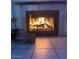 Cozy fireplace with a warm glow and decorative tile surround, creating an inviting ambiance in the home at 8863 W Greer Ave, Peoria, AZ 85345