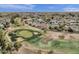Aerial view of a neighborhood with a well manicured golf course, desert landscaping, and green spaces at 915 S Saranac Ave, Mesa, AZ 85208