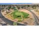 Aerial view of a lush green golf course surrounded by mature trees, and neighborhood homes at 915 S Saranac Ave, Mesa, AZ 85208
