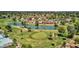 An aerial view of a golf course with a serene pond, palm trees, and community homes at 915 S Saranac Ave, Mesa, AZ 85208