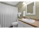 Clean bathroom featuring a vanity, toilet, and shower with a white curtain at 915 S Saranac Ave, Mesa, AZ 85208