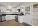 Well-lit kitchen with modern appliances, white cabinetry, and a convenient back door at 915 S Saranac Ave, Mesa, AZ 85208