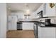 Updated kitchen with stainless steel appliances, white cabinets, and black counters at 915 S Saranac Ave, Mesa, AZ 85208