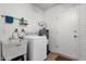 Laundry room with white appliances, sink, tile flooring, and exterior access door at 915 S Saranac Ave, Mesa, AZ 85208