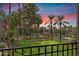 Scenic view from a balcony overlooking a lush green lawn, mature trees, and condo buildings with a colorful sunset sky at 9708 E Via Linda -- # 2328, Scottsdale, AZ 85258