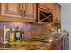 Close-up of a kitchen featuring custom cabinets, granite countertops, mosaic tile backsplash, and wine rack at 9708 E Via Linda -- # 2328, Scottsdale, AZ 85258