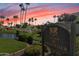 Scenic view of The Racquet Club sign near a pond, lush landscaping, and palm trees against a vibrant sunset sky at 9708 E Via Linda -- # 2328, Scottsdale, AZ 85258