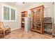 Bright office featuring ample storage with built-in shelving, a display cabinet, and large shuttered window at 10136 E Southern Ave # 1082, Mesa, AZ 85209