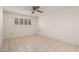 This bedroom features white walls, tile floors, and a window with shutters at 10319 W Twin Oaks Dr, Sun City, AZ 85351