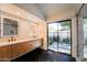 Modern primary bathroom with double sinks, wood cabinets, and outdoor access at 10360 N 98Th St, Scottsdale, AZ 85258