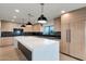 Modern kitchen featuring wood cabinets, an island with a waterfall countertop, and pendant lighting at 10360 N 98Th St, Scottsdale, AZ 85258