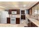 Well-lit kitchen featuring granite countertops, stainless steel appliances, and warm wooden cabinetry at 10809 W El Dorado Dr, Sun City, AZ 85351