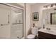 Well-lit bathroom featuring a shower with a glass door, a toilet, and a vanity with a sink at 10822 W Mimosa Dr, Sun City, AZ 85373