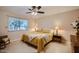 This bedroom features a window with natural light, a ceiling fan, and a bed with neutral tones at 10822 W Mimosa Dr, Sun City, AZ 85373