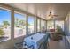 Bright sunroom featuring several windows, comfortable seating, and a dining area with a view of the outdoors at 10822 W Mimosa Dr, Sun City, AZ 85373