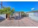 Charming backyard featuring a covered patio, gravel landscaping, and mature palm trees for a serene outdoor experience at 11223 W Missouri Ave, Youngtown, AZ 85363