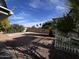 Spacious backyard featuring a rock landscape, trees, and a wood fence at 11223 W Missouri Ave, Youngtown, AZ 85363